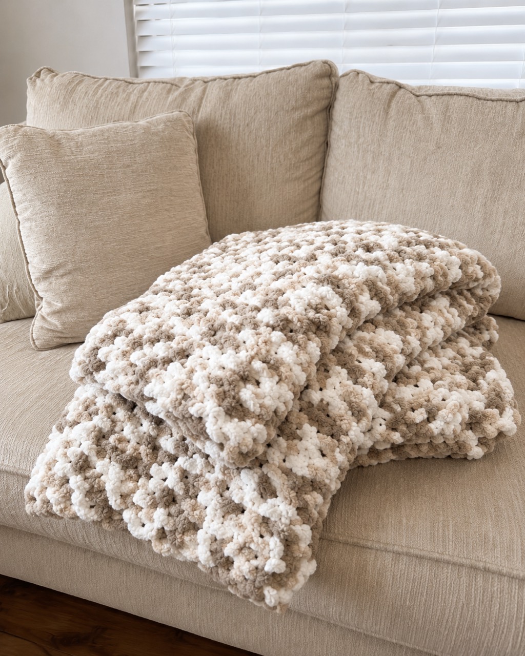 Neutral Camo handmade chunky throw folded on a neutral sofa